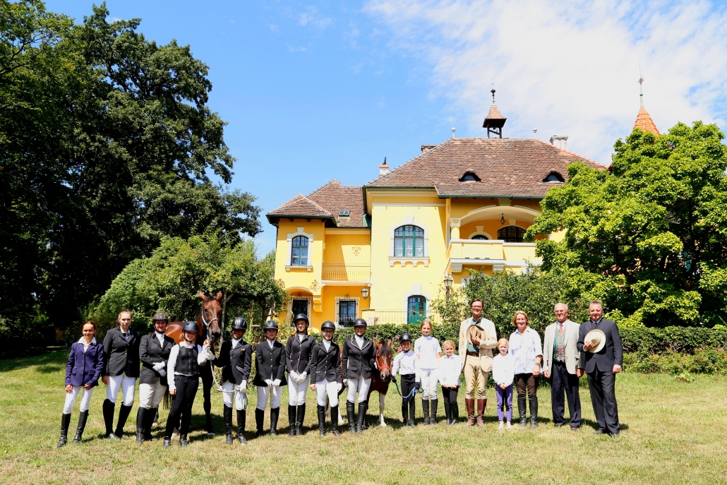 Die Teilnehmerinnen und der Teilnehmer der vom Reit- und Fahrclub Gut Aichhof am 10.08.2019 organisierten Pferdesportprüfung mit Präsident Ludwig Hoffmann (Richter), Bundeskulturreferent Otto Kurt Knoll (offizieller Beisitzer des NÖ Pferdesportverbandes) und Präsidentin Ludmila Spiegelfeld (Reit- und Fahrclub Gut Aichhof) im Park des Gutes Aichhof. © Maria Hörmandinger
