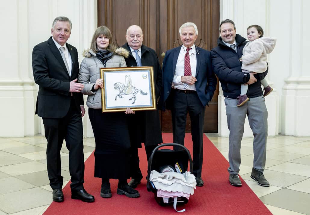 Präsident Otto Kurt Knoll vom »Reitkultur-Verein Weiß-Blau-Gold« präsentiert mit Vereinsmitglied Cornelia Haase (Vertreterin der jungen Generation im Verein), Präsident Franz Kager vom NÖ Pferdesportverband, dem Doyen der Reitkunst Arthur Kottas-Heldenberg (einst Erster Oberbereiter an der Spanischen Hofreitschule) und Vereinsmitglied Otto Hofer (Geschäftsführer von Happy Horse Holzedeleinstreu) mit seiner Tochter das Bild „Severin von Noricum hoch zu Ross“ am 8. Jänner 2025 auf der Kaiserstiege des Stiftes Klosterneuburg. © Imre Antal