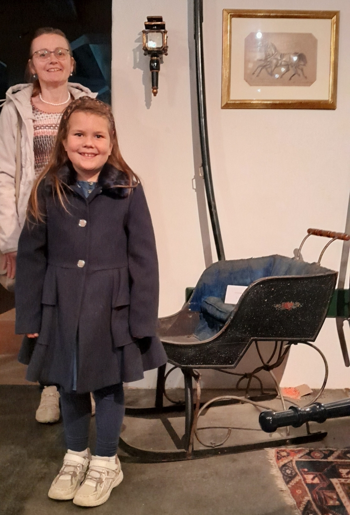 Katharina Rupp-Stanschitz mit ihrer Mutter Barbara Rupp-Stanschitz vor einem historischen Kinderschlitten. © privat